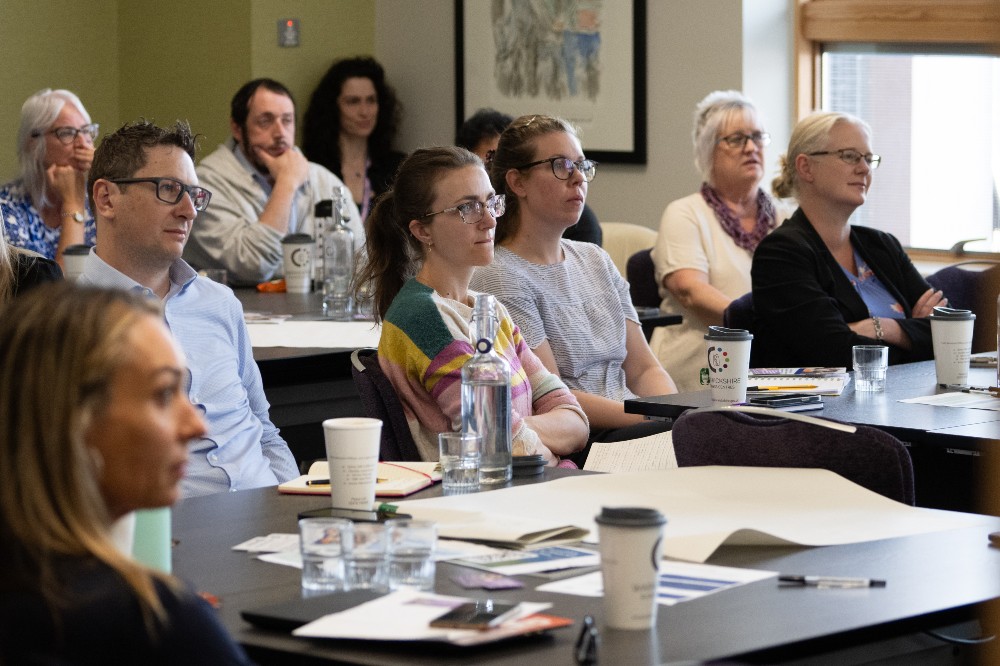 A group of people sat at tables at a wellbeing forum event