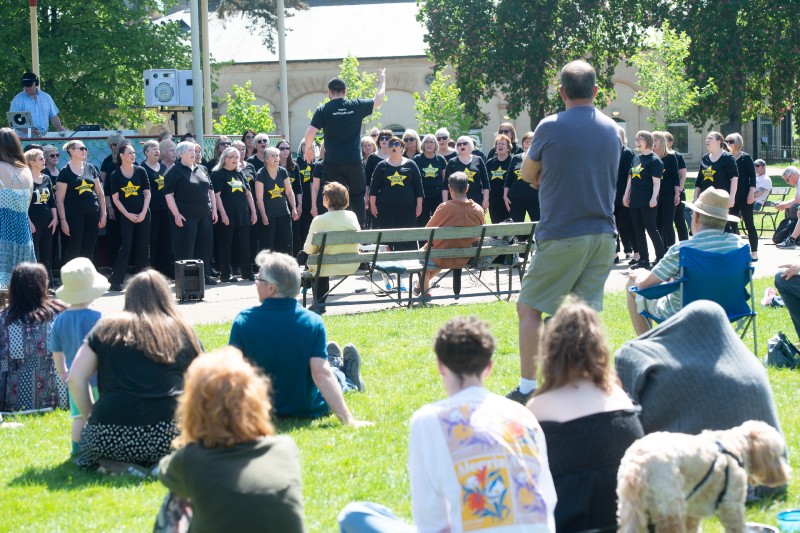 Choir outdoor in front of crowd.
