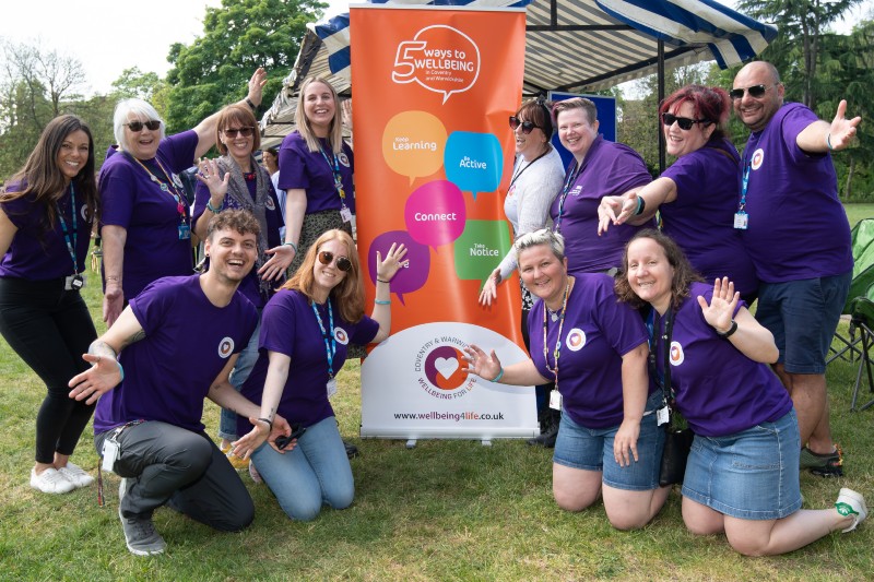 Team in purple shirt crouching in front of their banner.